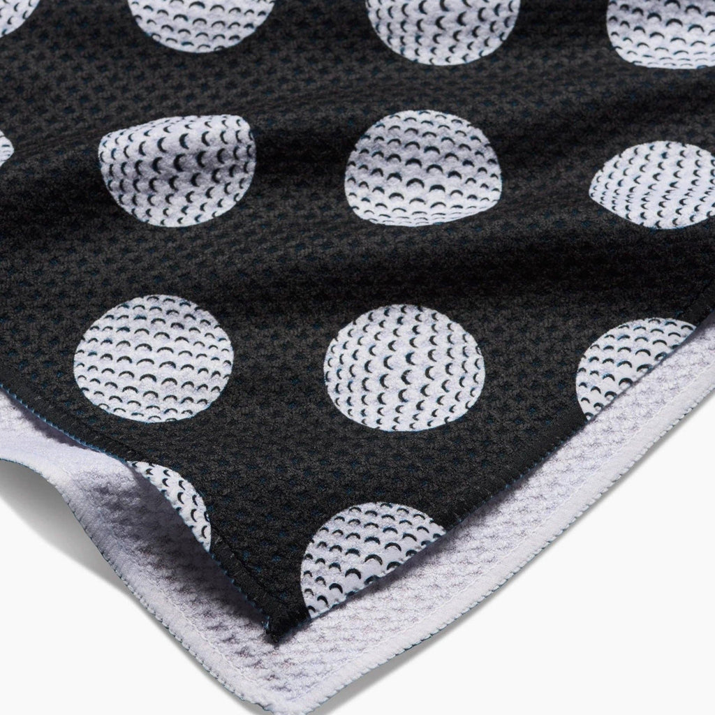 black tea towel with white golf ball polka dots