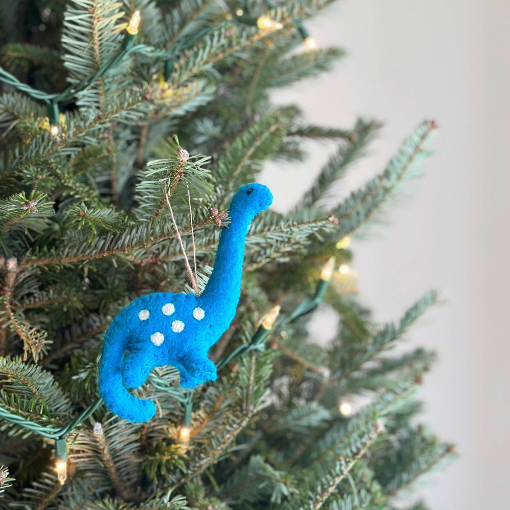 Get in the adventurous holiday spirit with our felt Christmas Brontosaurus! Made from eco-friendly wool felt and handcrafted in Nepal, this fair-trade ornament is perfect for decorating your Christmas tree. Designed in Florida, this cute and quirky ornament will add a playful touch to your holiday decor!