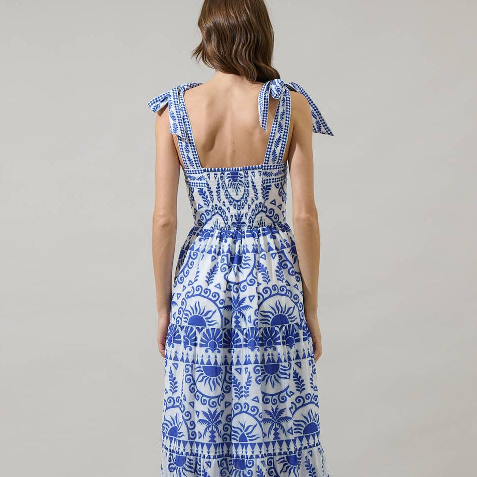 It’s easy to create a cute look when you’ve got the Rivera Tropics Emely Tiered Maxi Dress. A blue print sits on a white background creating this fun and creative print. It features shoulder tie straps, tiered layers, and a smocked back. White heels would be a perfect match to this dress.