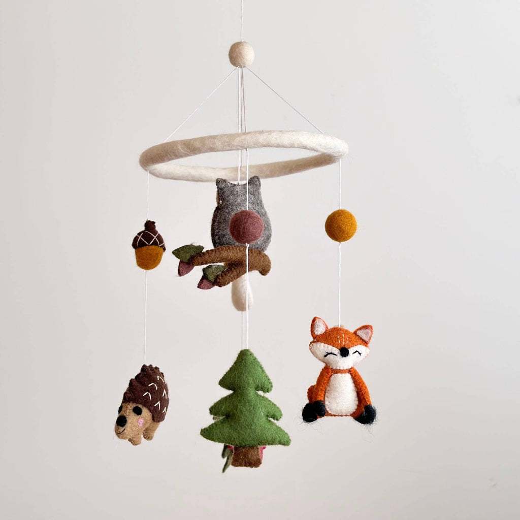 Elevate your baby's nursery with the charm of a Forest Animal Theme Mobile! Crafted from handcrafted wool felt, this delightful mobile brings the enchanting forest world to life. Suspended from a felt hoop for gentle, soothing movement, it features a daring owl, a cute fox, a charming mushroom, a friendly hedgehog, a tiny acorn, and a towering pine tree. Welcome the magic of the forest into your baby's room with this captivating mobile, creating a dreamy and imaginative atmosphere for your little one.