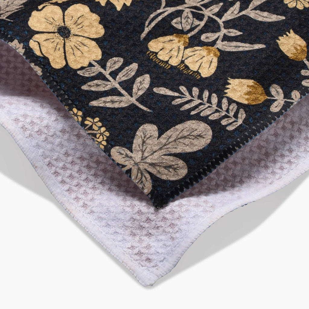 black tea towel with yellow/green floral pattern