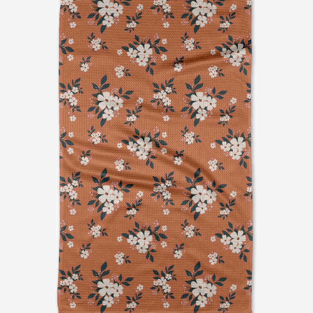 orange tea towel with white cutesy floral pattern