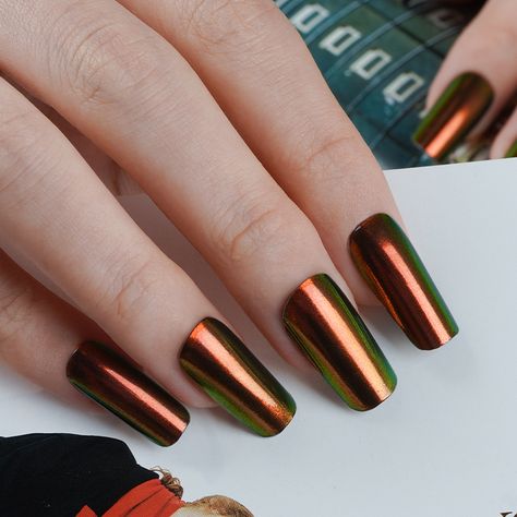 Coppery color chrome nails with a shimmery green iridescent effect.