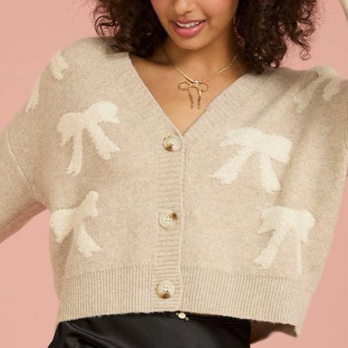 Wrap yourself up in style with our All Over Bow Crop Cardigan! This playful and unique piece features charming bows throughout, adding a touch of whimsy to any outfit. Stay warm and fashionable all season long with this must-have addition to your wardrobe.