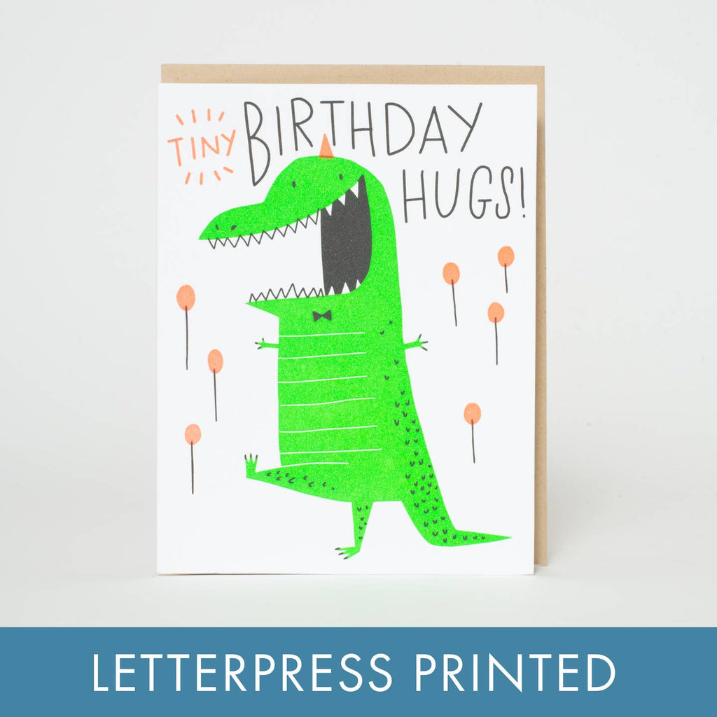 Celebrate someone's birthday with this charming Birthday Tiny Hugs Dino Letterpress Greeting Card by Hello!Lucky. Printed with high-quality letterpress, this adorable card features a friendly dino giving tiny hugs, bringing love and laughter to their special day. Let them know you're thinking of them with this playful and unique card.