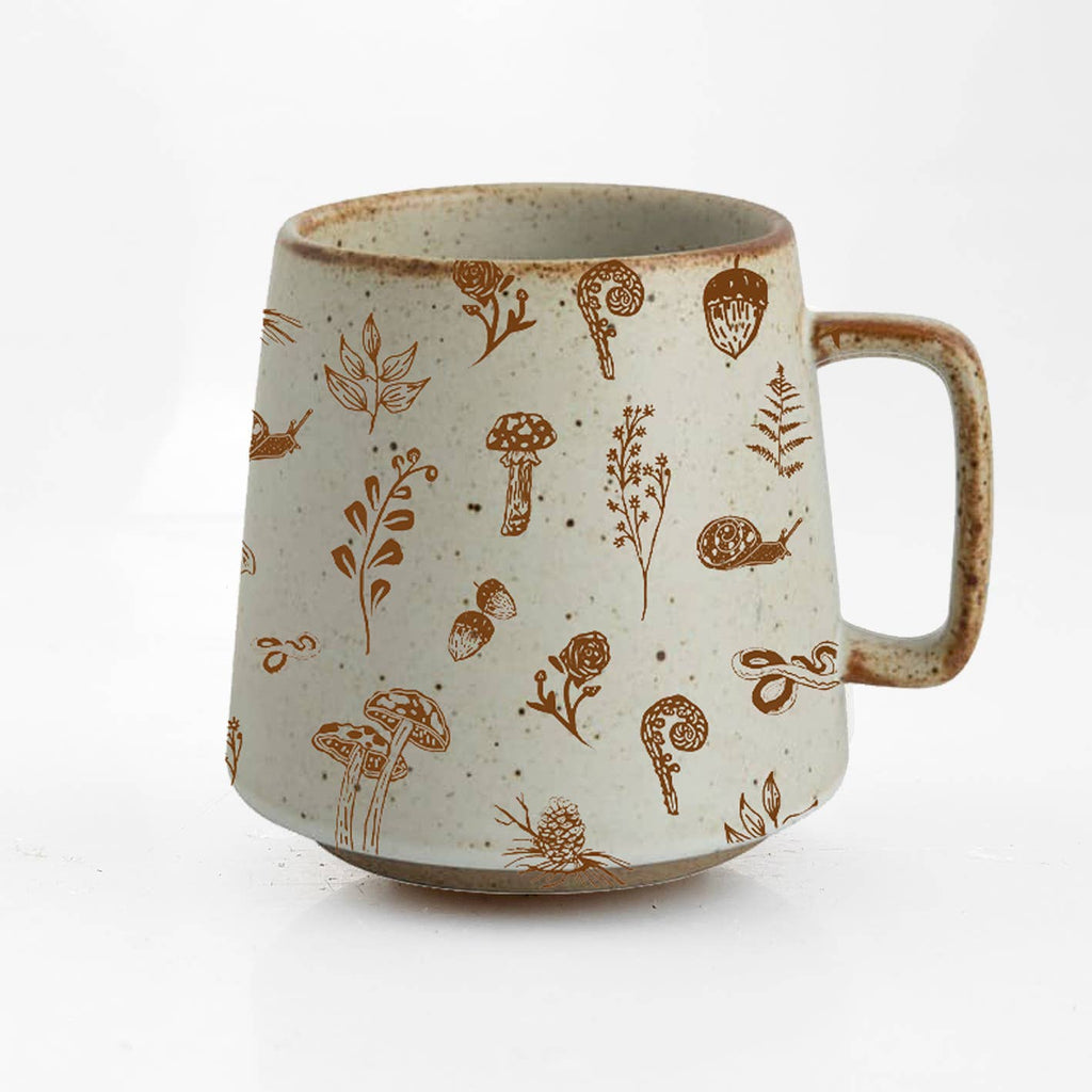 Bring the magic of the forest to your customers with our Woodland Stoneware Mug, a beautifully crafted piece that blends nature-inspired design with exceptional quality.

Featuring originally hand-drawn illustrations of woodland creatures and flora—like a snake, fern, acorn, and mushroom—this mug transports every sip to a tranquil forest setting.