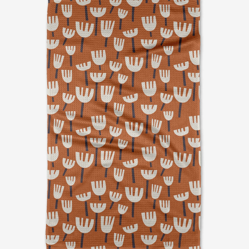 orange tea towel with white floral pattern