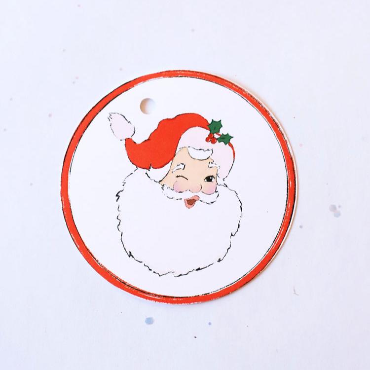 white circle gift tag with a vintage santa face a bright red border