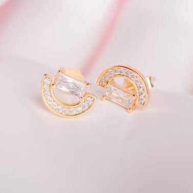 The Torrid stud earrings get their name from the tropical, hot, and humid regions nearing the equator. With dazzling semi-circles belted by baguettes, these earrings are sure to make you feel celestial. 925 sterling silver with gold plating extra layer of tarnish resistance Manufactured for our curated collection.