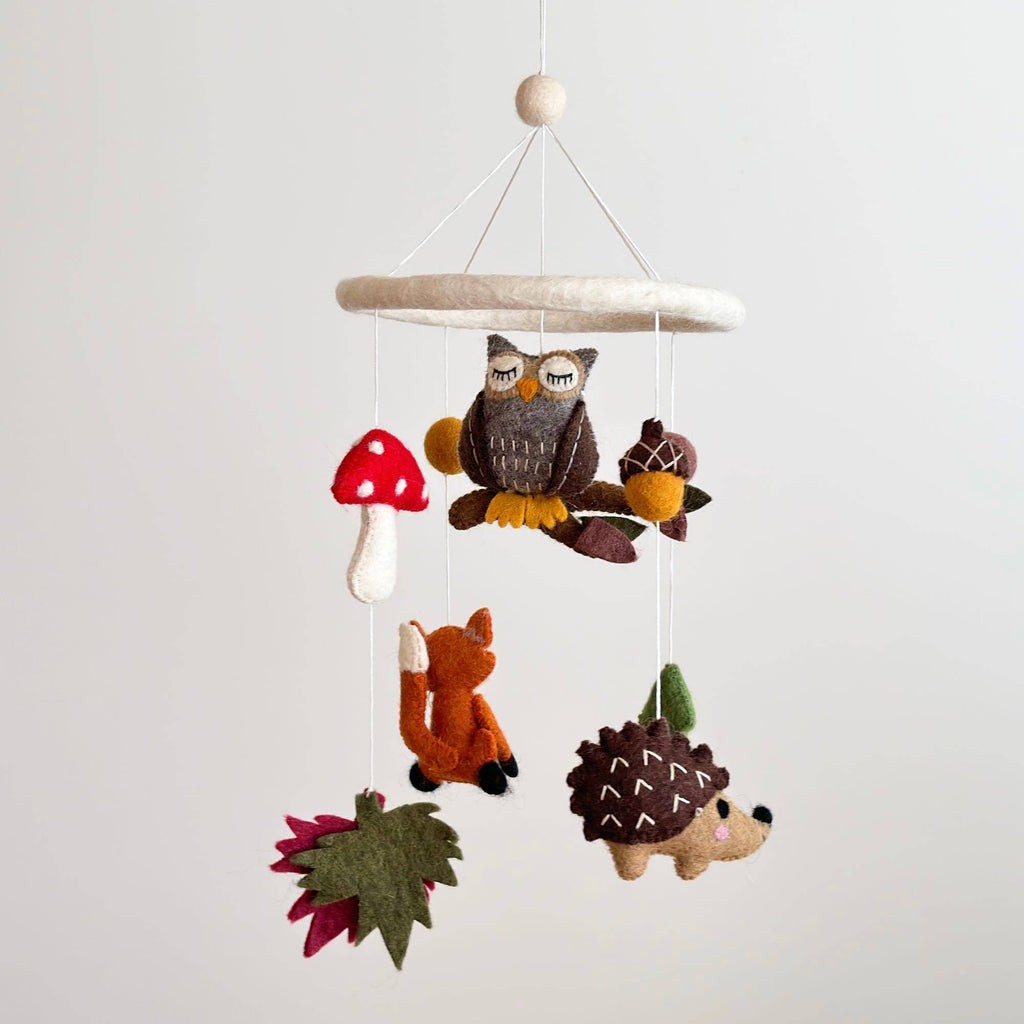 Elevate your baby's nursery with the charm of a Forest Animal Theme Mobile! Crafted from handcrafted wool felt, this delightful mobile brings the enchanting forest world to life. Suspended from a felt hoop for gentle, soothing movement, it features a daring owl, a cute fox, a charming mushroom, a friendly hedgehog, a tiny acorn, and a towering pine tree. Welcome the magic of the forest into your baby's room with this captivating mobile, creating a dreamy and imaginative atmosphere for your little one.