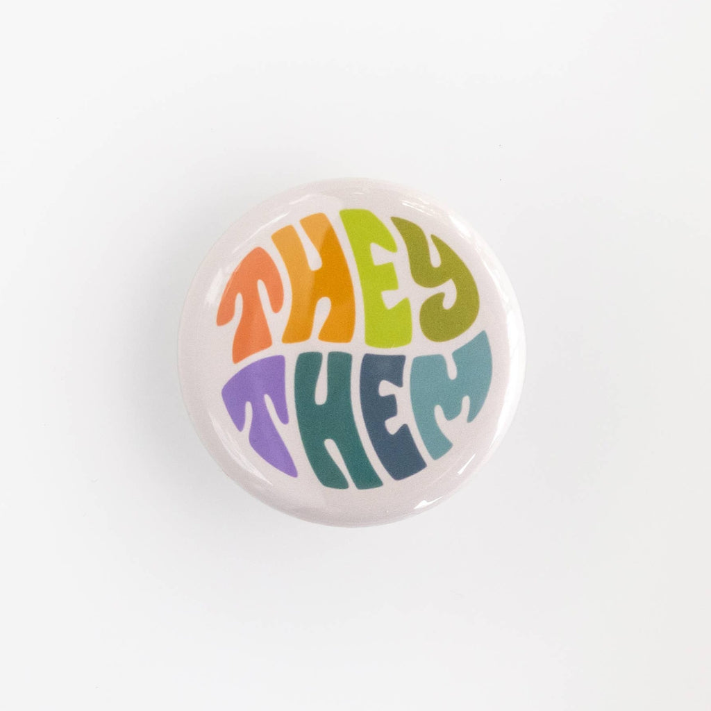 Wear your pronouns with pride with these cute retro-style buttons! This pinback button displays "They/Them" pronouns in a colorful palette. It is the perfect way to let others know how to address you and to show your support for the LGBTQ+ community!  Size: 1.25" pinback button