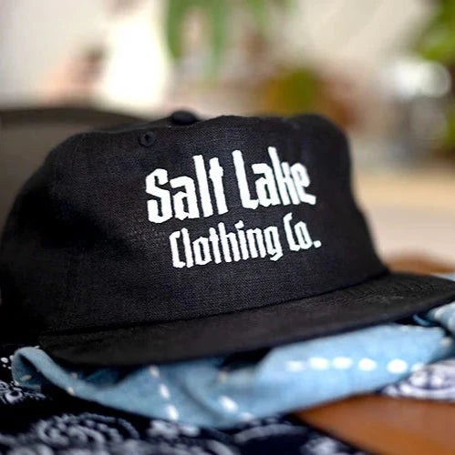 Black linen cap featuring the Salt Lake Clothing Co logo.