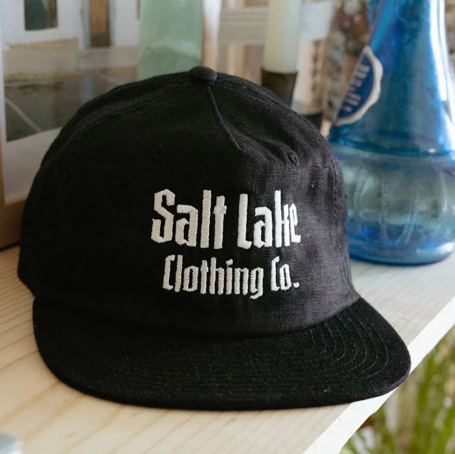 Black linen cap featuring the Salt Lake Clothing Co logo.