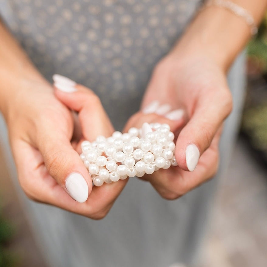 Elevate your ponytail game with Hattie Pearl Ponytail! It features beautiful pearls and a stretchy elastic band for a snug fit. Perfect for adding a touch of elegance to your everyday look. Pearl-fect for all hair types!