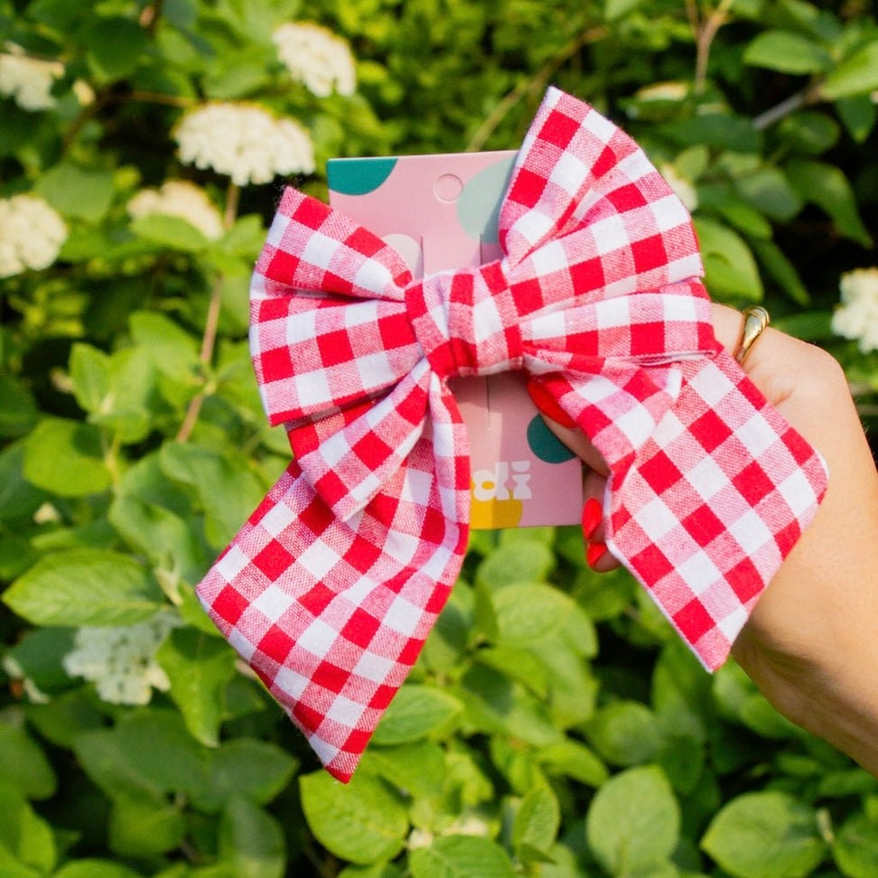 Put a bow on it with our Red Gingham Bow Clip. This chunky bow, in a classic red and white gingham pattern, will add a touch of French style to any look. The French style barrette ensures a secure hold so you can rock this look all day (and night) long!