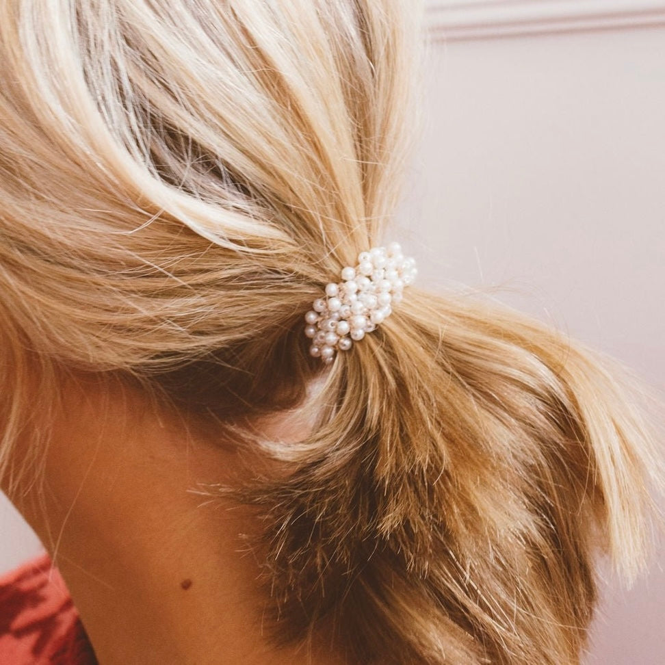 Make your ponytail fancy and elegant with the Tiny Pearl Hair Tie! This stretchy pearl ponytail holder adds a touch of sophistication to any hairstyle. Perfect for a fancy night out or to elevate your everyday look. Upgrade your ponytail game today!