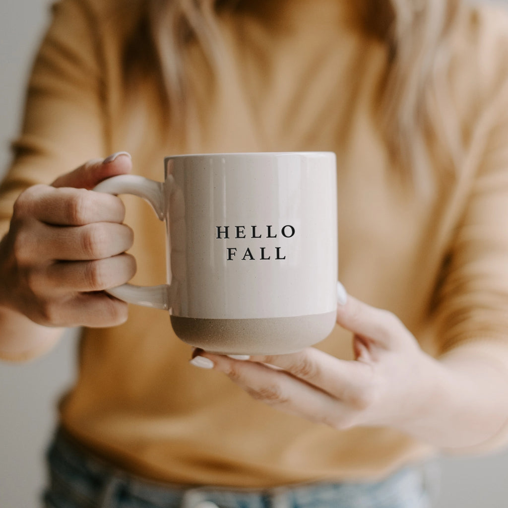 Say hello to the fall season with this cozy stoneware coffee mug! Cream with black lettering that reads "hello fall", this mug is perfect for sipping on your favorite warm drink. Embrace the autumn vibes with every sip.