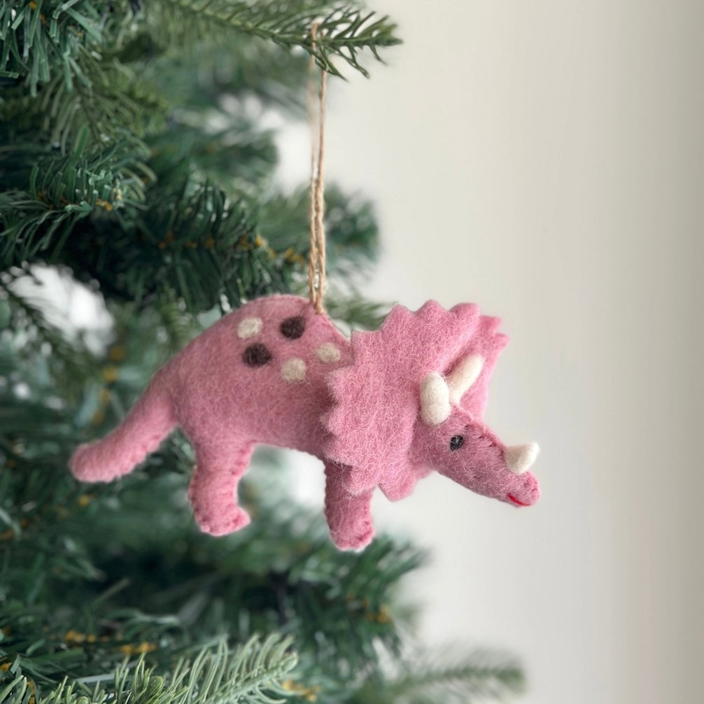 Get in the holiday spirit with our felt Christmas Pink Triceratops! Made from eco-friendly wool felt and handcrafted in Nepal, this fair-trade ornaments is perfect for decorating your Christmas tree. Designed in Florida, this cute and quirky ornament will add a playful touch to your holiday decor!