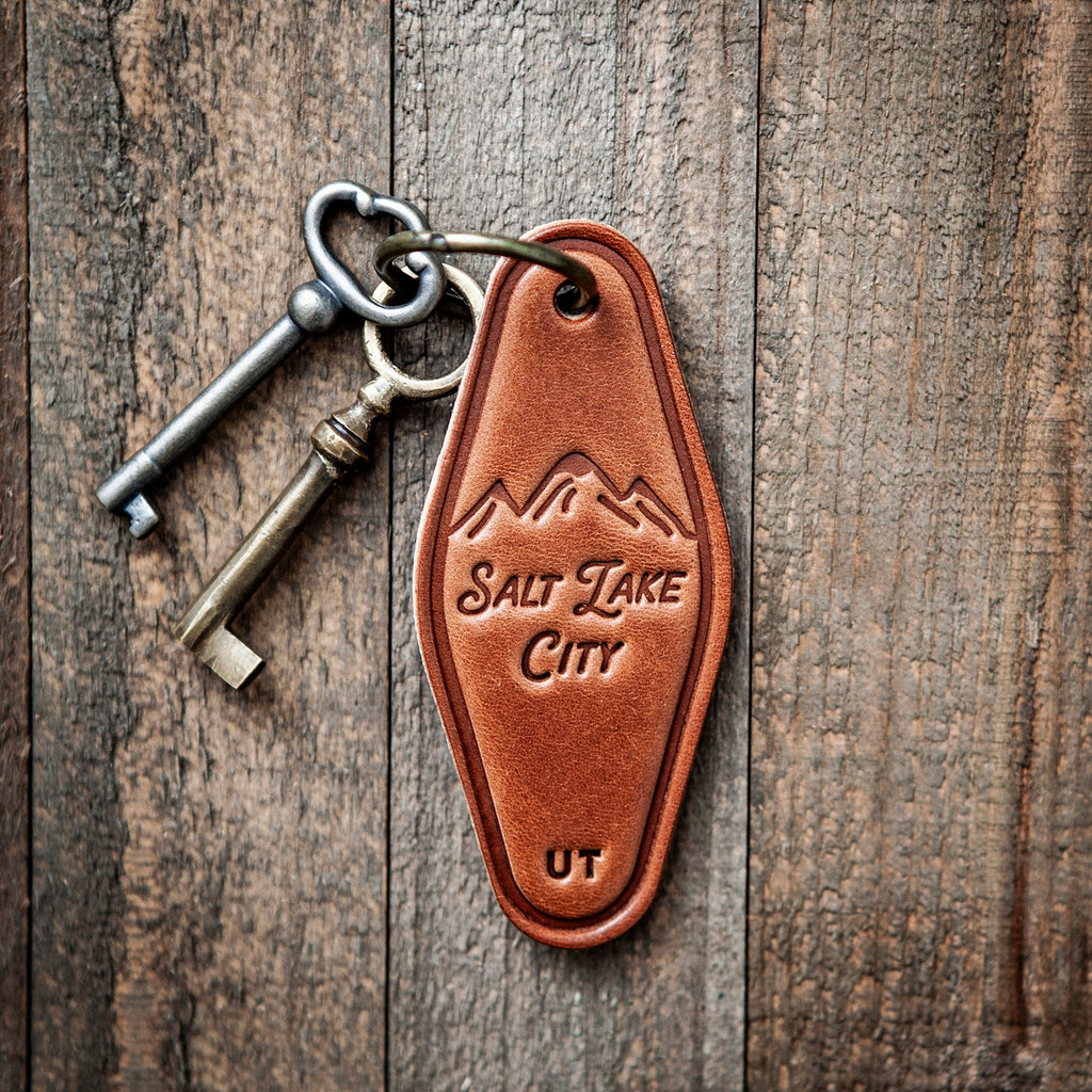 This leather keychain comes in a classic motel style with “Salt Lake City” beautifully written in calligraphy on the front. Our leather keychains are cut and pressed by hand from some of the thickest and finest harness leather available, and patina beautifully as they age.