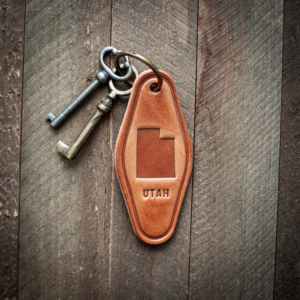 This Utah themed leather keychain comes in a classic motel style. Our leather keychains are cut and pressed by hand from some of the thickest and finest harness leather available, and patina beautifully as they age.

Size: 4”

Hardware: Antique Bronze 1 inch hinged keyring