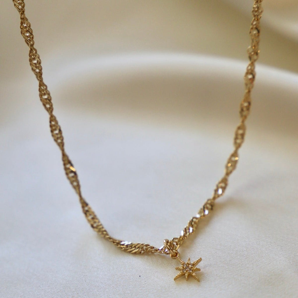 Our Janelle Necklace features a stunning twisted chain with a delicate star pendant. This piece pairs great with some of our more simpler chains or stands out beautifully on its own