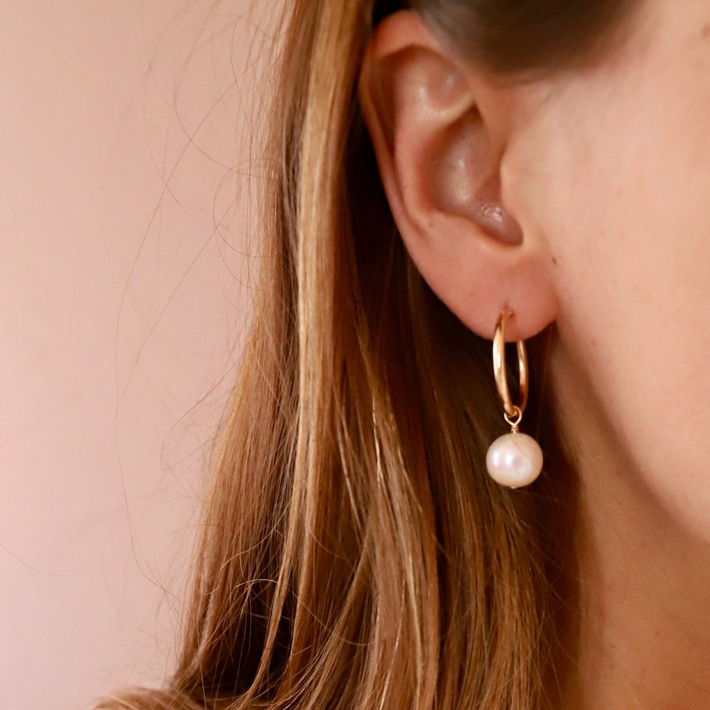 Add a touch of elegance with our Audrey Pearl Hoop Earrings. These stylish hoops feature delicate pearls for a classy yet playful look. Perfect for any occasion, these earrings are sure to add a touch of charm to any outfit. 