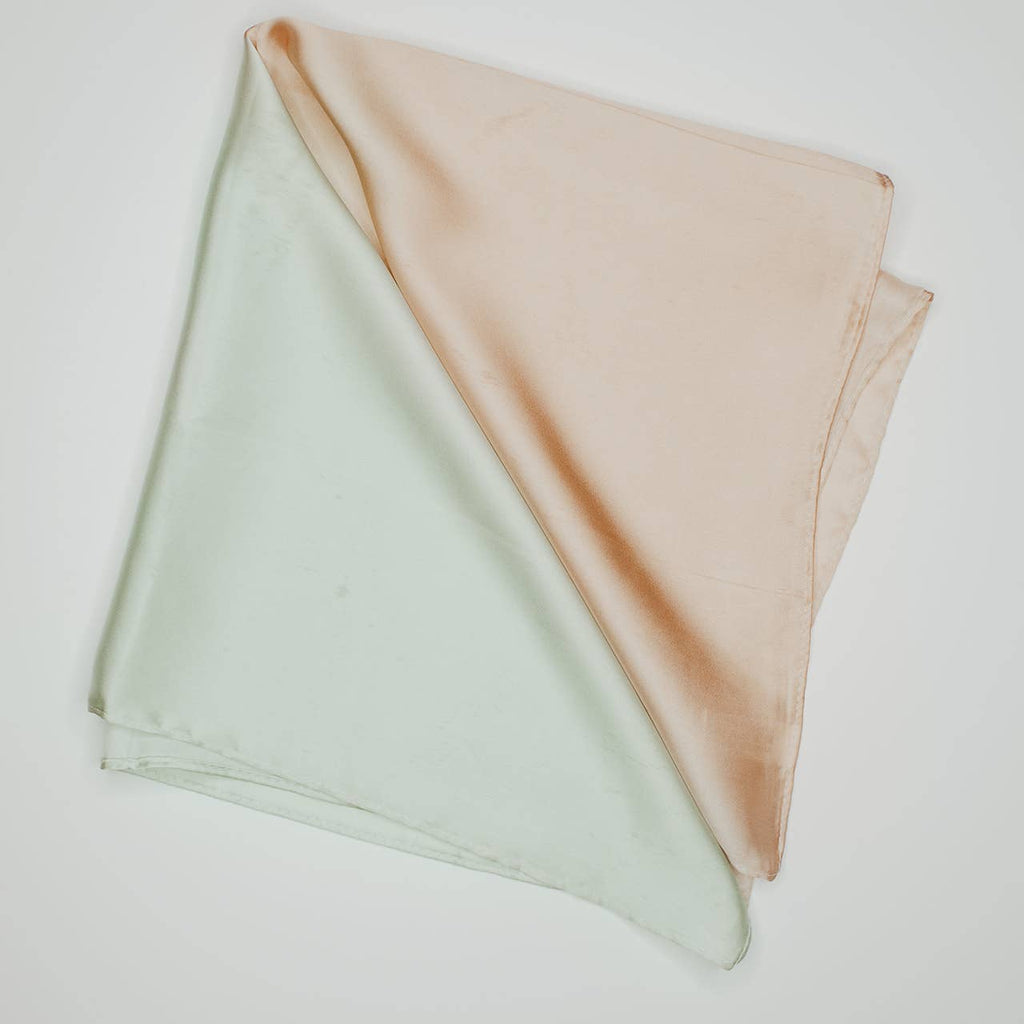 Revamp your hair game with our Silk Bandana in a playful mint and tan color! This versatile hair scarf adds a touch of style and fun to any look. Whether you tie it around your ponytail or wear it as a headband, our two toned bandana is the perfect accessory for any occasion.