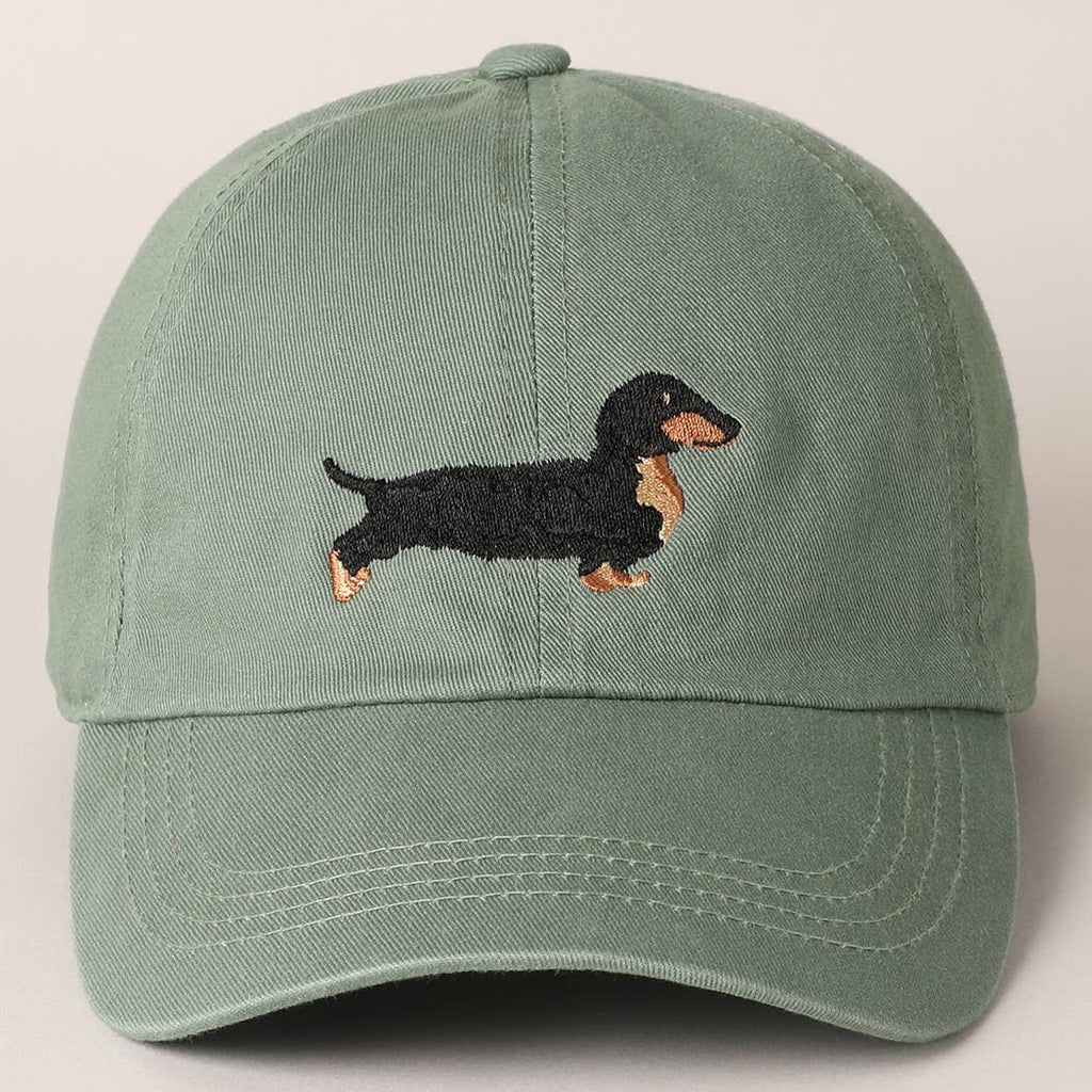 Get ready to walk the dog in style with our Dachshund Embroidered Baseball Cap! This washed sage hat features a playful embroidered Dachshund dog, perfect for any dog lover. Whether you're a baseball dad or just love a good ball cap, this unique and quirky accessory will add a touch of humor to any outfit.