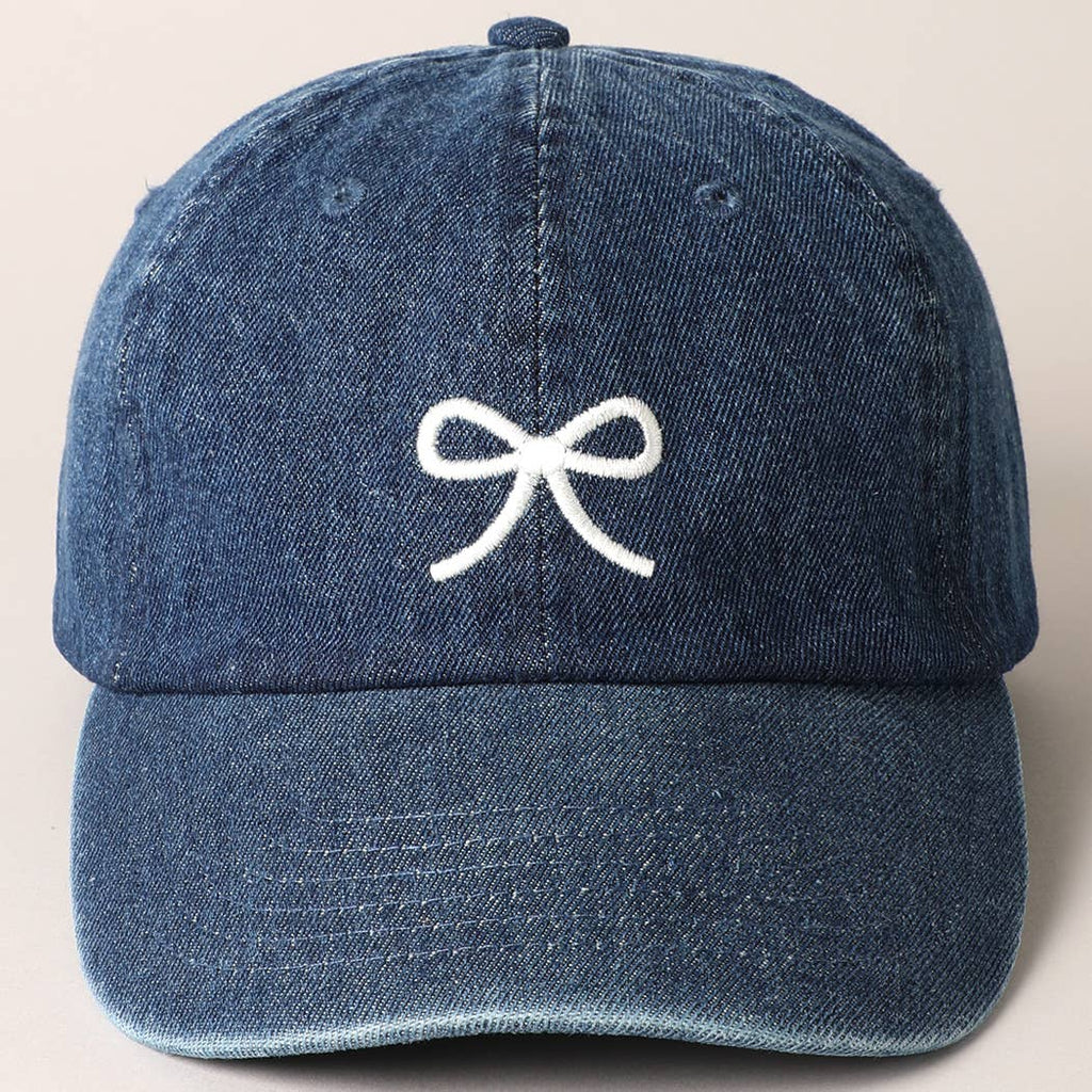 Top off your look with this charming embroidered baseball cap in washed dark denim. With a dainty bow detail, this cap is the perfect blend of playful and stylish. Stay cool and on trend with this must-have accessory. (Psst, it's also great for bad hair days!)