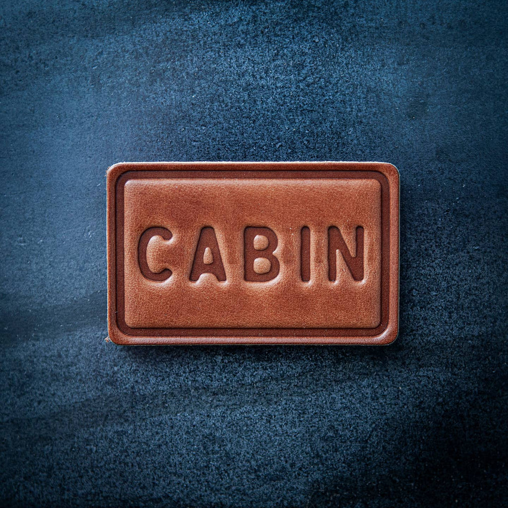 This leather magnet comes in a block style featuring “CABIN” in chunky lettering. Our leather magnets are cut and embossed from some of the thickest and finest harness leather available, and patina beautifully as they age.