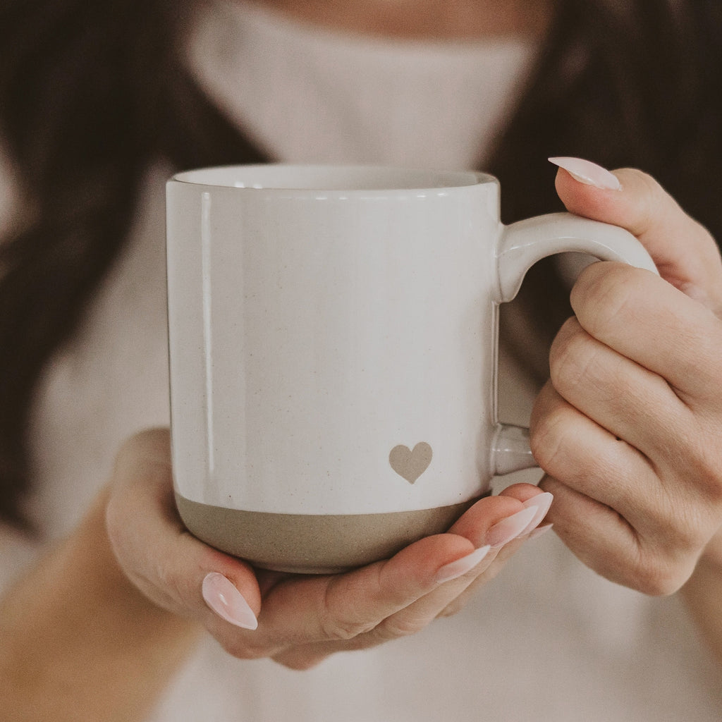 Enjoy a blend of charm and functionality with our Heart Coffee Mug, crafted from durable stoneware with a subtle heart detail in the bottom corner. Perfect for everyday use or as a thoughtful gift for Valentine’s Day, Mother's Day, weddings, engagements, bridal showers, and anniversaries.