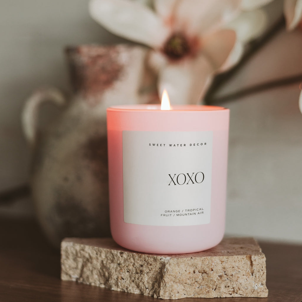 Indulge in the luxurious aroma of our Xoxo Soy Candle. With its tropical fruit scent, this candle will transport you to a paradise of relaxation and romance. The matte pink design adds a touch of elegance, while the wood wick creates a soothing ambiance. Treat yourself or a loved one to this exclusive 15 oz candle.