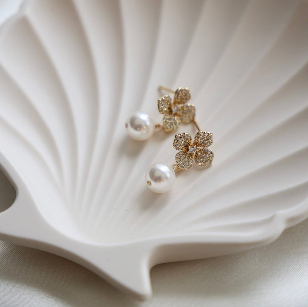 Add a touch of whimsy to your wardrobe with our Flora Pearl Studs. These delicate studs are the perfect accessory for any occasion. With their elegant design and playful twist, you'll be sure to stand out from the crowd. Don't miss out on adding some flair to your jewelry collection!