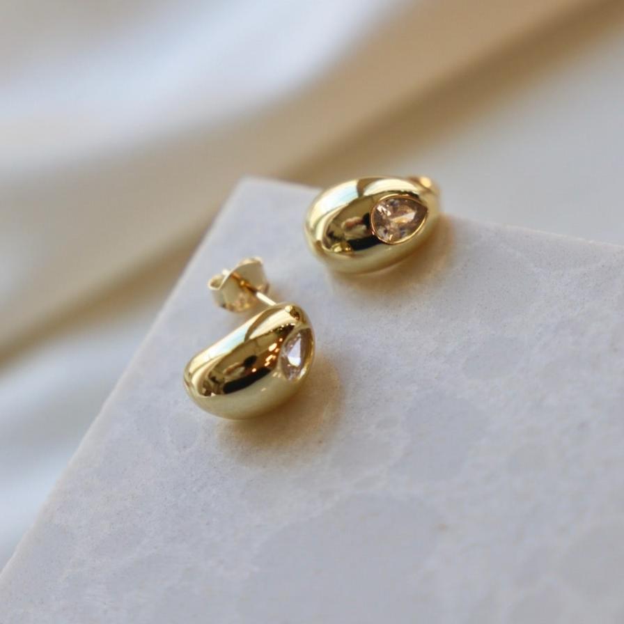 These Jasmine Studs will add a subtle sparkle to any outfit. Crafted with teardrop studs and a teardrop cubic zirconia center, they boast a unique and elegant design. Enjoy a timeless look with these exquisite studs.