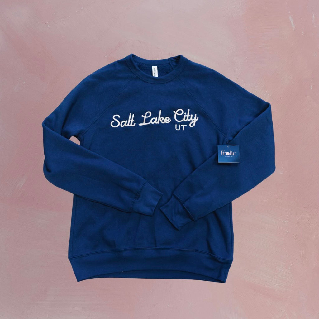 Stay cozy in our Salt Lake City Crewneck Sweatshirt in a beautiful shade of navy! Made with sponge fleece, this wide neck sweatshirt is perfect for snuggling up on chilly days. So grab your sweatshirt and explore the city in style!