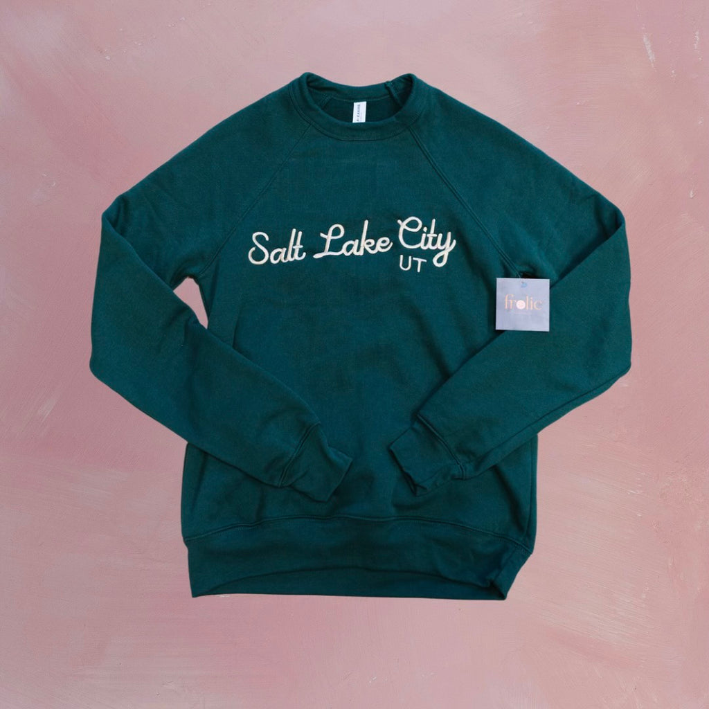 Stay cozy in our Salt Lake City Crewneck Sweatshirt in a beautiful shade of forest green! Made with sponge fleece, this wide neck sweatshirt is perfect for snuggling up on chilly days. So grab your sweatshirt and explore the city in style!