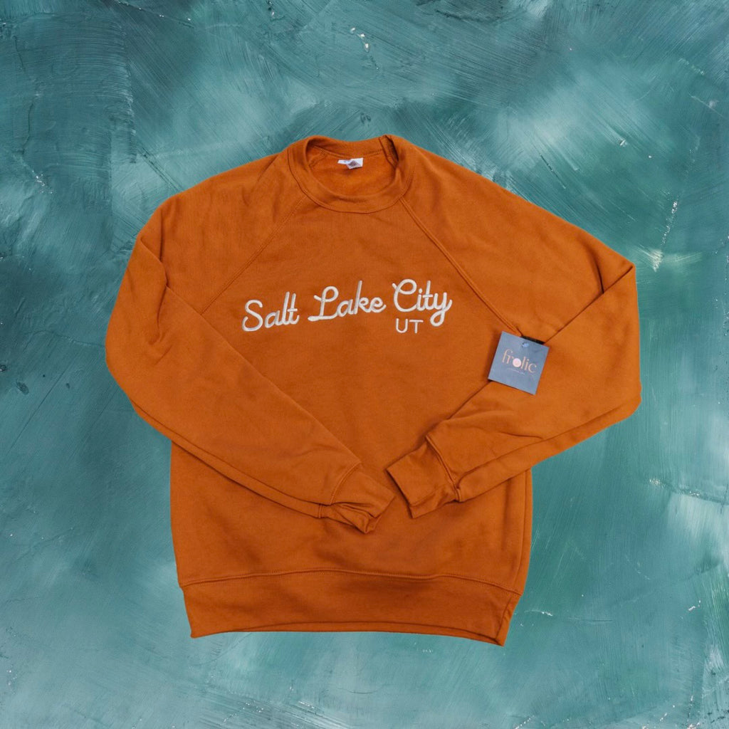 Stay cozy in our Salt Lake City Crewneck Sweatshirt in a beautiful shade of autumn orange! Made with sponge fleece, this wide neck sweatshirt is perfect for snuggling up on chilly days. So grab your sweatshirt and explore the city in style!