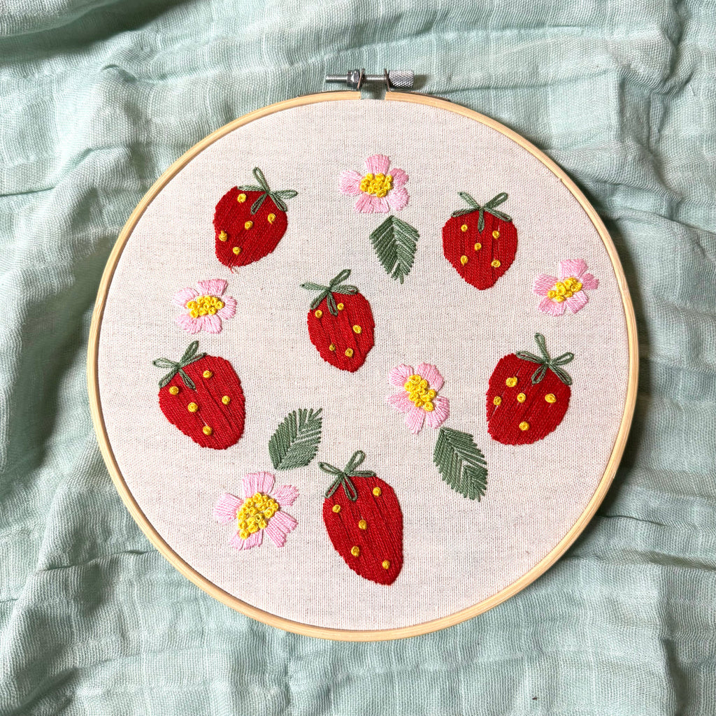 8 inch embroidery hoop featuring 6 red strawberries and 5 pink flowers