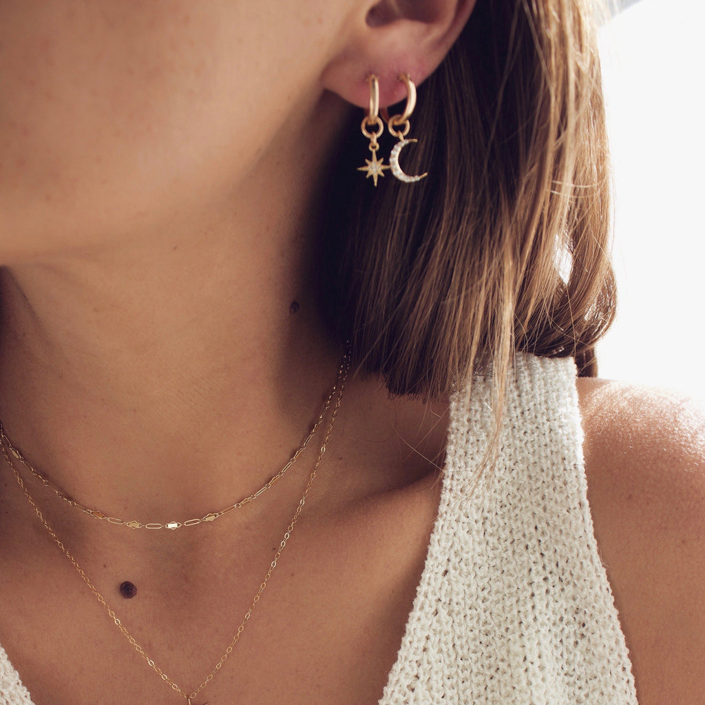 Our most loved earring, the Celestial Star and Moon Hoops are mis-matched perfection. This whimsical pair can be worn together or paired with another style. You can also slide the moon and star charms off for a great staple pair of small hoop earrings.