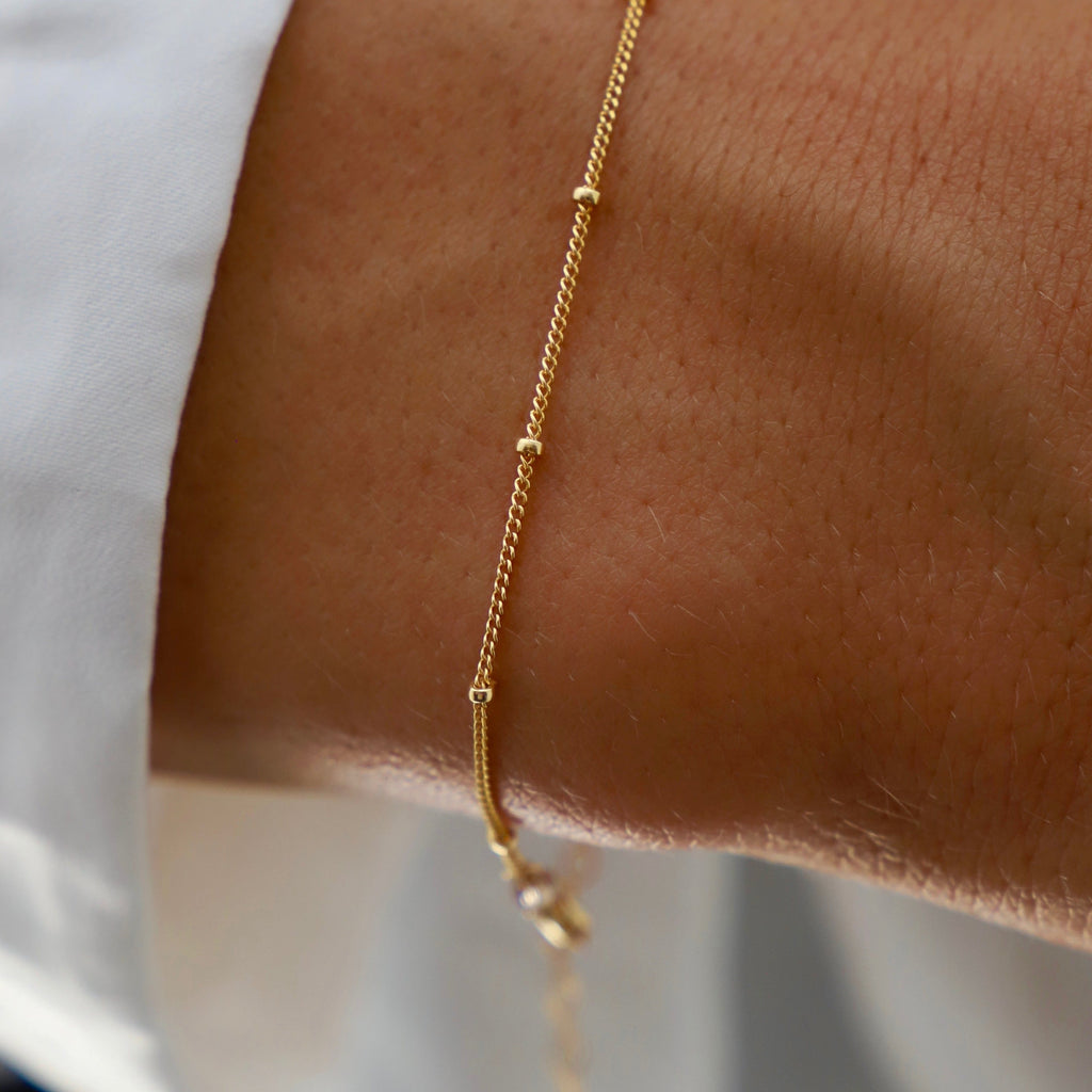 This dainty bracelet features a petite ball chain, perfect for adding a delicate touch to any outfit. Its lightweight design ensures comfortable wear, while its versatile style makes it suitable for any occasion. Dress it up or down for a touch of subtle elegance.