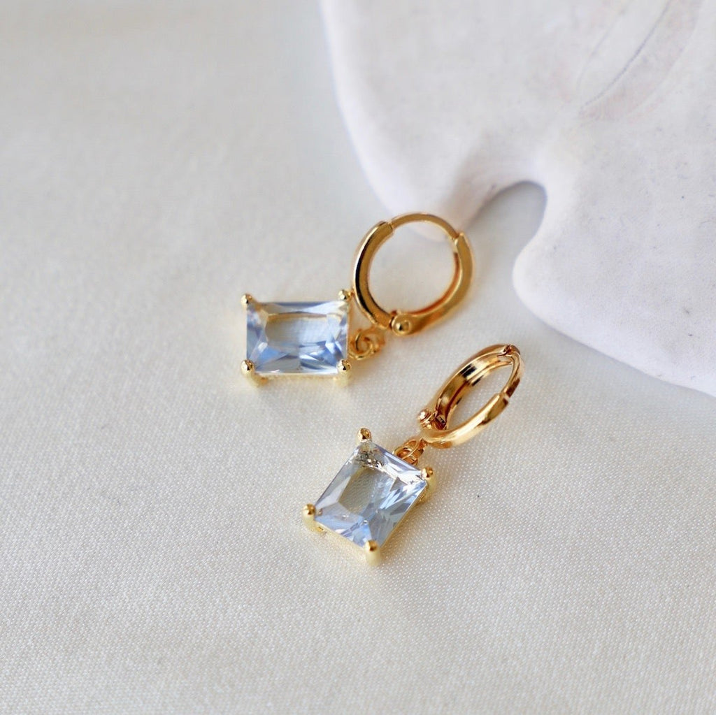 The centerpiece of our new huggie earring is the Light Sapphire rectangle, which adds a touch of elegance to any outfit. Perfect for adding a pop of color, whether you're dressing up for a special occasion or as an everyday timeless accessory. In Gold