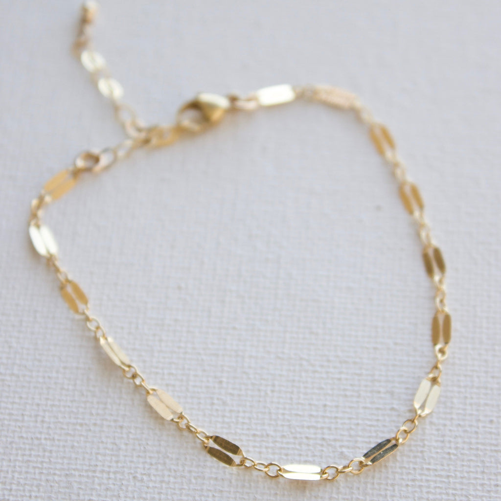 Add flare to your ensemble with this dainty gold filled dapper chain bracelet. The perfect accessory for any outfit, this delicate bracelet will make you stand out in a subtle way. Don't be shy to add a little shimmer and shine to your wardrobe.