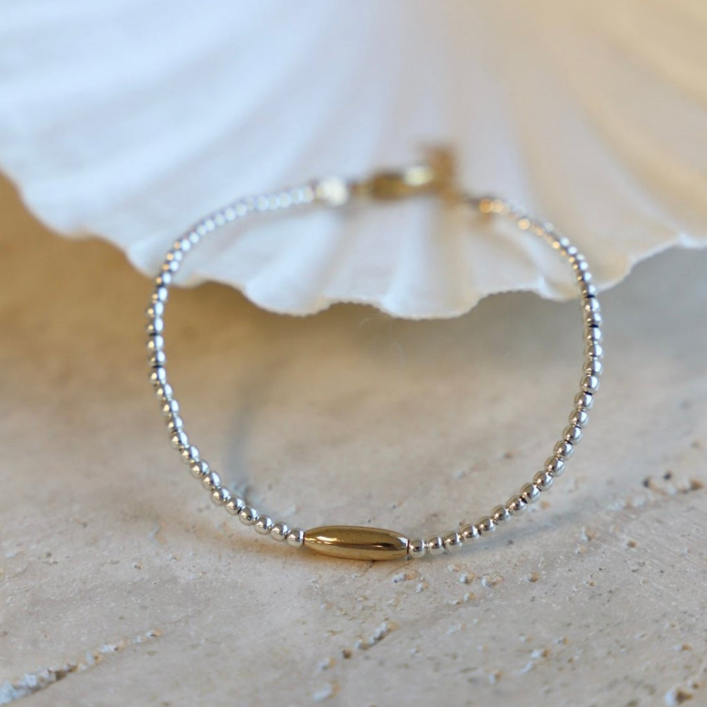 The Miniature Roman Bracelet features a unique combination of silver beaded links and a gold accent oval. Crafted with high quality materials, this chic bracelet is perfect for accessorizing an outfit and adding a touch of sparkle