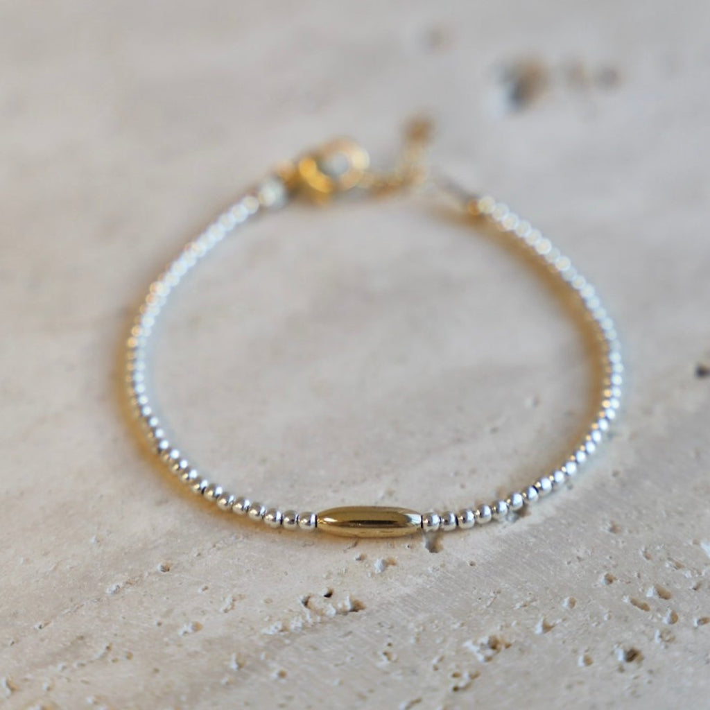 The Miniature Roman Bracelet features a unique combination of silver beaded links and a gold accent oval. Crafted with high quality materials, this chic bracelet is perfect for accessorizing an outfit and adding a touch of sparkle