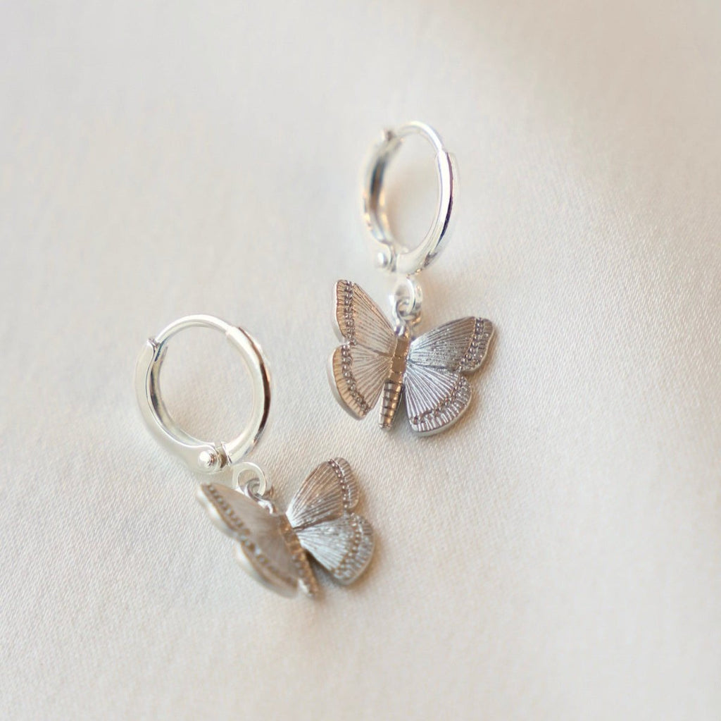 You will love the Billie Butterfly Huggies, they are a silver butterfly on a silver huggie that will shine on your ear. Pair them with a stud to create a layered look.