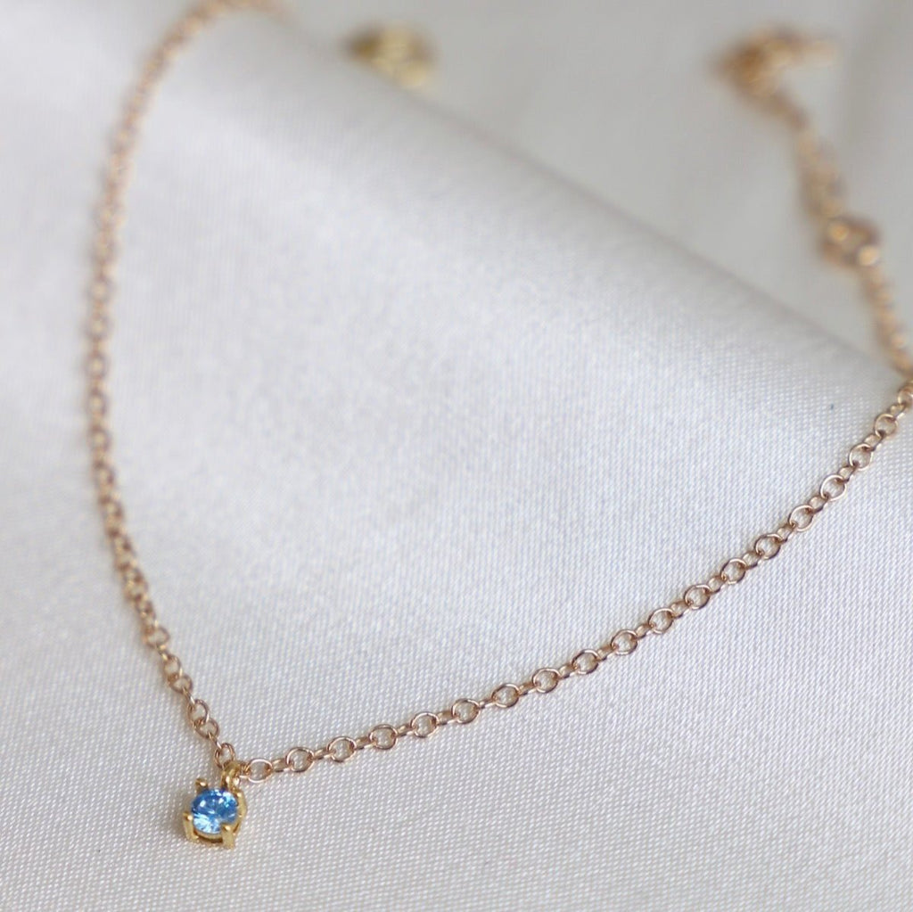 This beautiful birthstone charm bracelet features a delicate gold chain and a unique birthstone charm, making it a perfect piece for a personalized gift or a special piece for yourself.