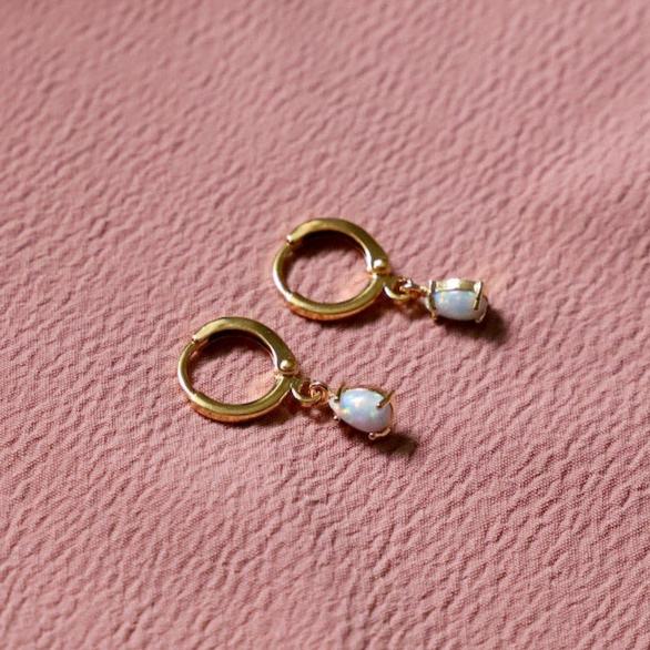 Experience playful elegance with our Miniature Opalite Huggies. These mini gold plated hoops feature opalite teardrops for a unique touch of style. Perfect for adding a touch of whimsy to any outfit. Hug your earlobes in style!