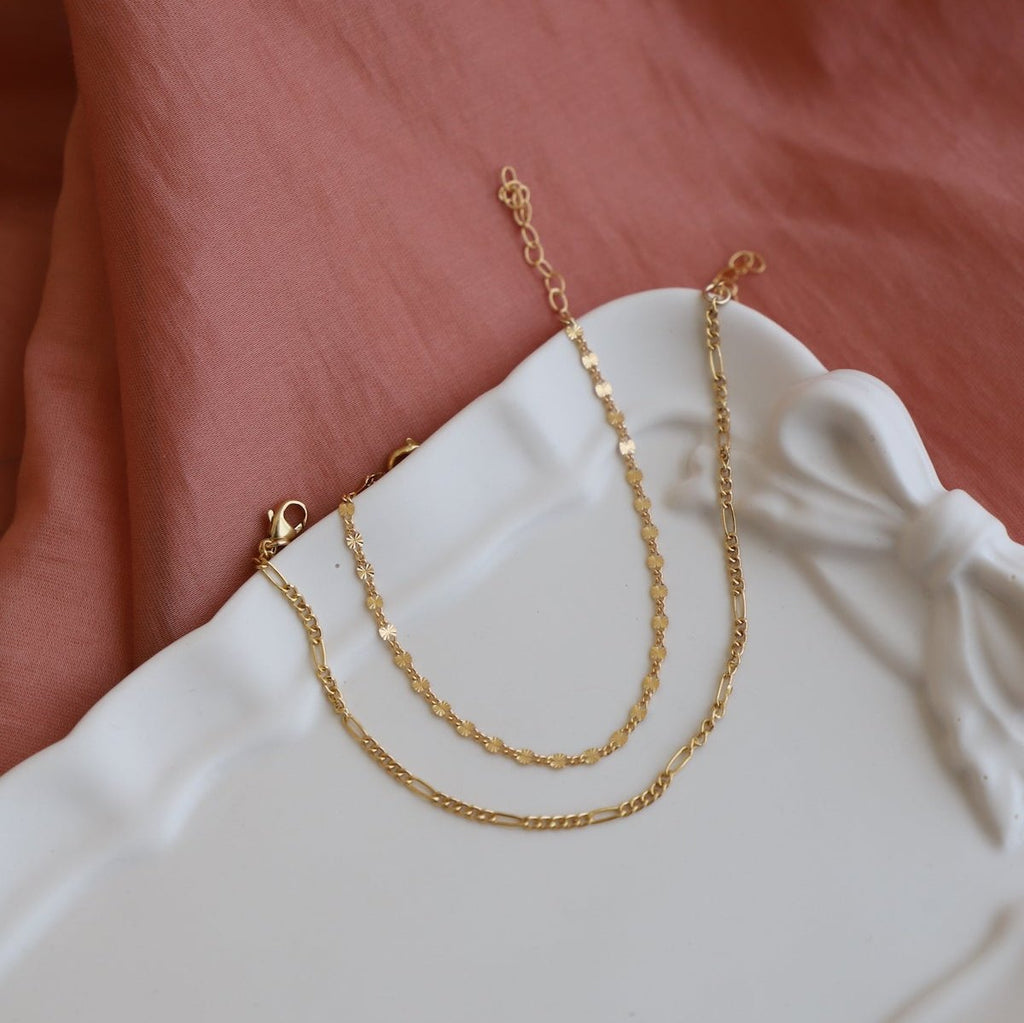 The Malibu Chain Bracelet features a delicate yet eye-catching gold-filled chain that adds a touch of elegance to any outfit. Its versatile design allows for easy layering, making it perfect for everyday wear.