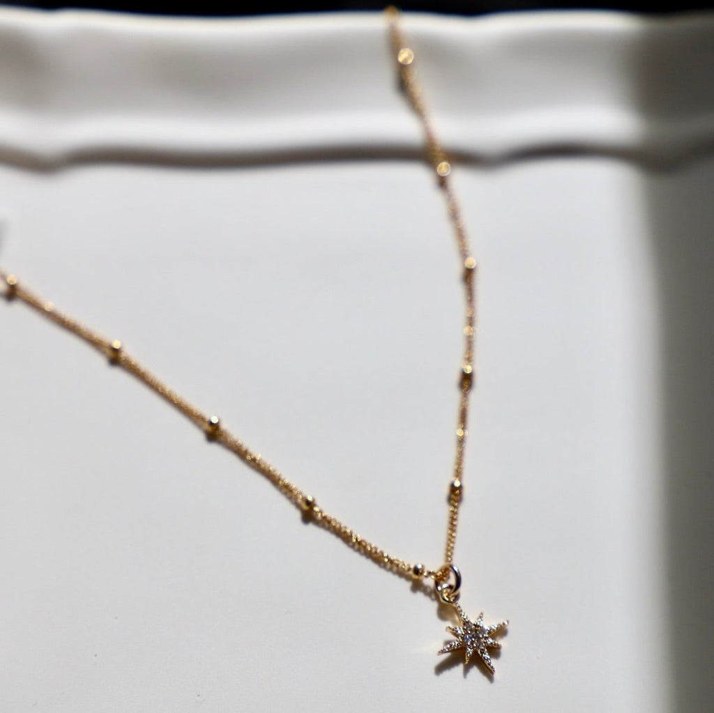 The Luna Star Necklace features a charming lunar design on a delicate satelite chain. Crafted with expert precision, this necklace is both elegant and versatile, perfect for adding a touch of celestial style to any outfit. Embrace the beauty of the night sky with this exquisite piece.