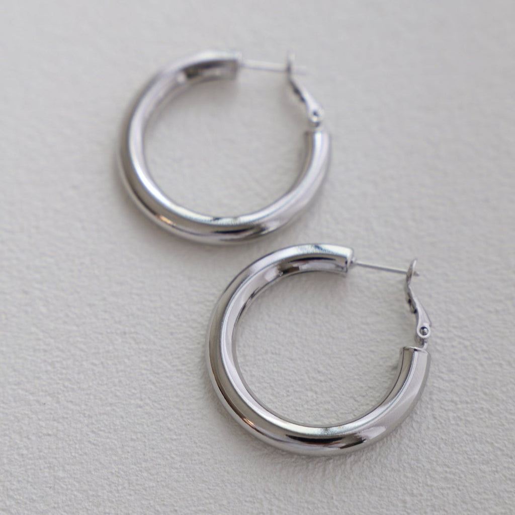 This medium thick hoop puts a modern spin on the classic hoop. We love to wear this sleek look on its own or with a simple stud. In silver